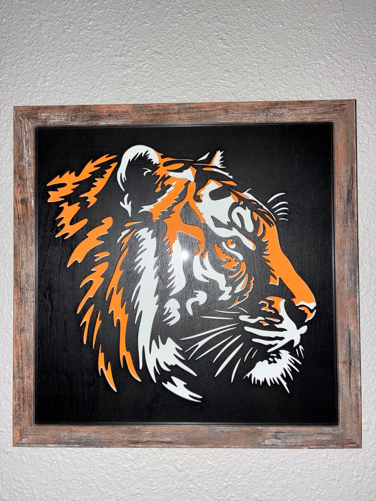Three-layered tiger artwork in a rustic frame
